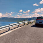 port douglas to cairns scenic drive, blue car on the road next to the coral sea