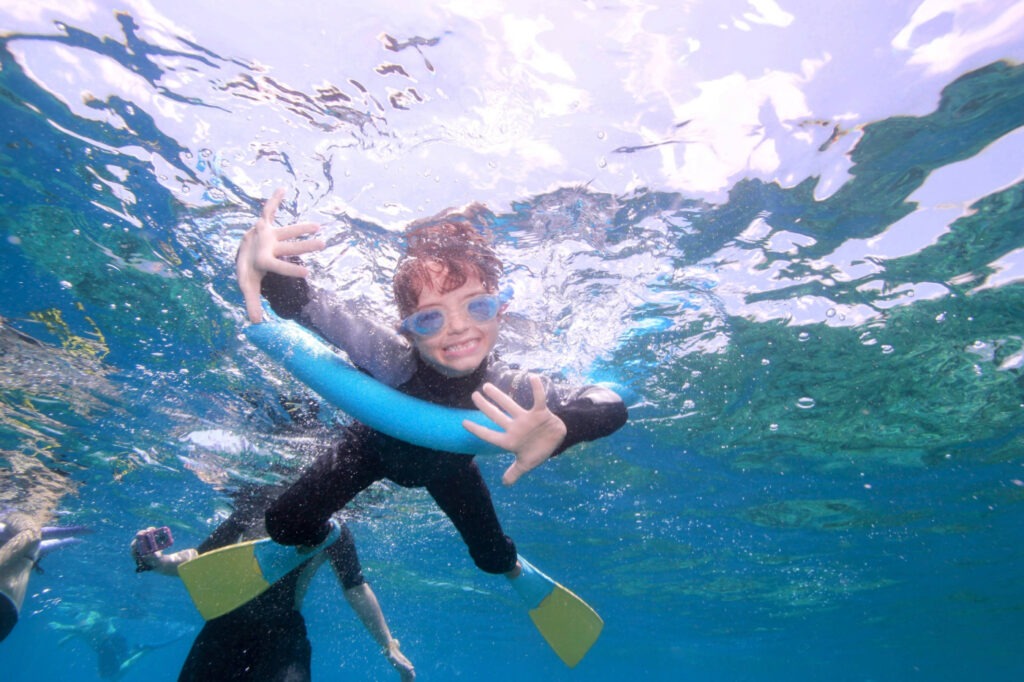 child swimming on The Great Barrier Reef near Cairns